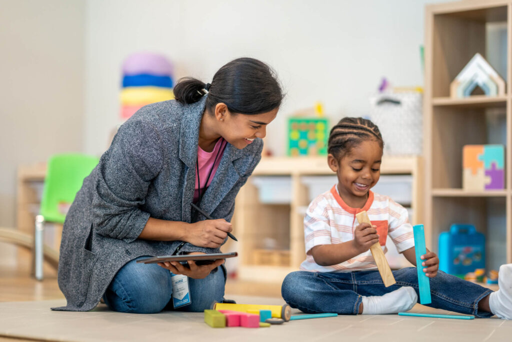 Child engaged in a learning assessment session with a supportive therapist