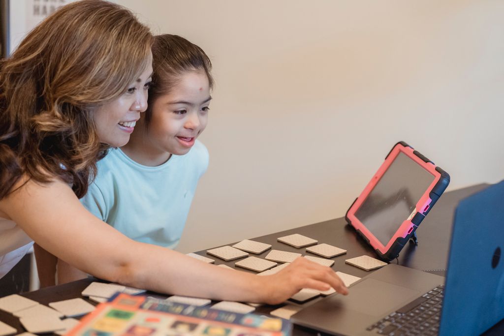 asian mother and daughter enjoying learning together with a laptop and educational cards indoors. 7943513